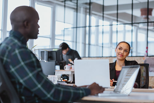 Executive discussing work with coworker in office
