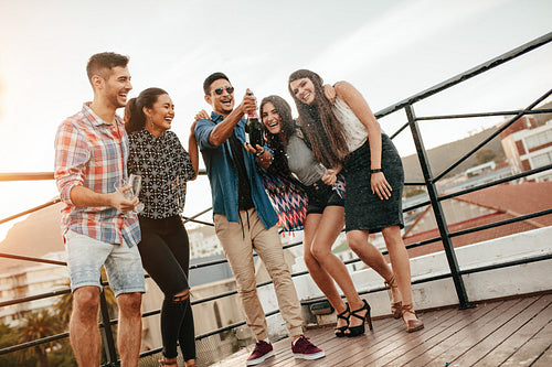 Young friends celebrating with champagne at party
