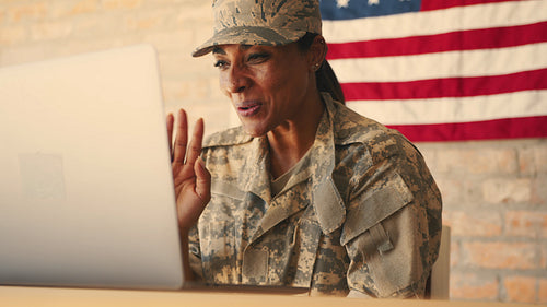 Female Marine doing a video call with her family using a laptop