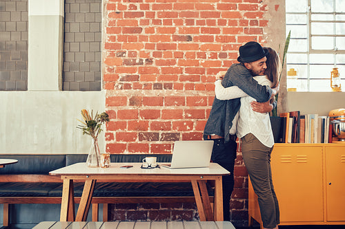 Couple greeting each other at a coffee shop