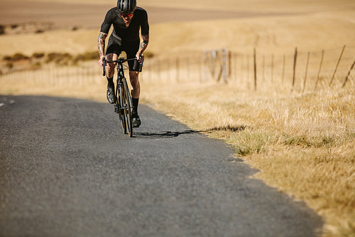 Professional bike rider riding on countryside road