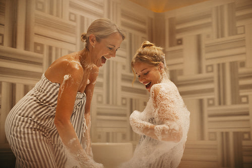 Happy women enjoying fun moments together in a hammam Turkish bath