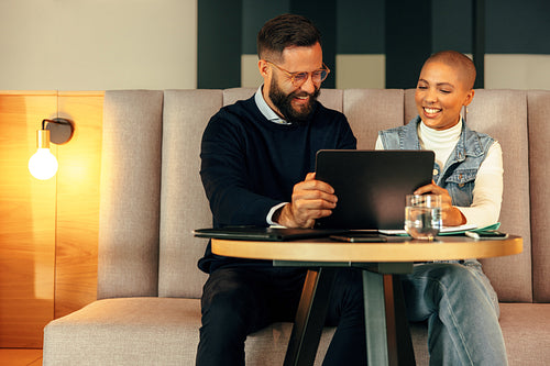 Two businesspeople taking a video call on a digital tablet
