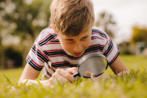 Boy exploring garden with his magnifier