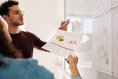 Business colleagues discussing work on a whiteboard in office