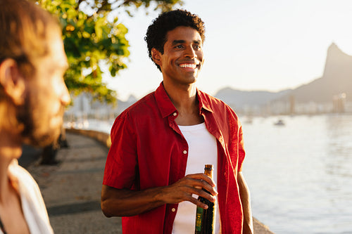 Smiling Brazilian man enjoying the sunset and a beer at Mureta Da Urca