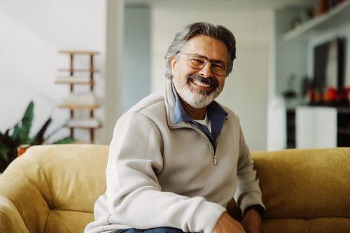 Senior man rests on a sofa in his living room