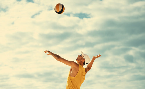 Male athlete blocking ball in mid-air during beach volleyball championship game