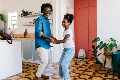 Dad and daughter enjoying playful dancing at home