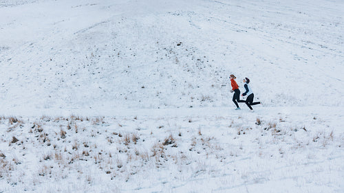 Outdoor running across winter snow shows women training as partners