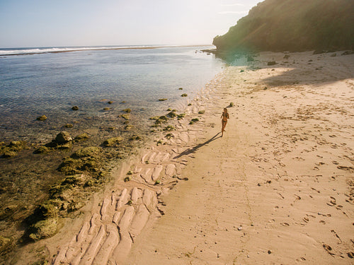 Beautiful tropical beach with a woman running