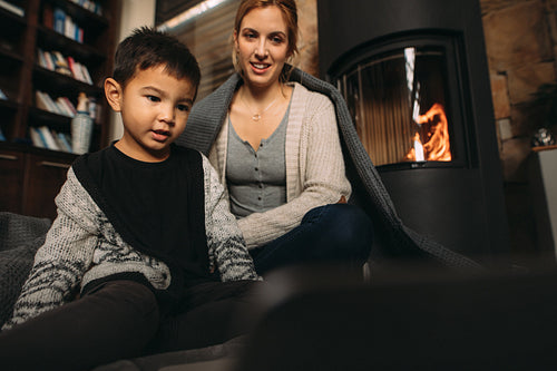 Little boy watching cartoon movie on laptop with mother