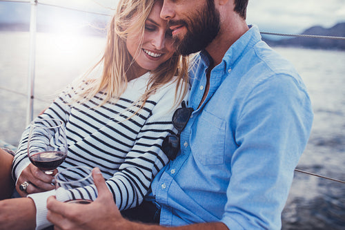 Romantic young couple on a boat with wine