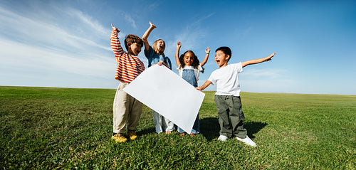Children outdoors celebrate togetherness with a banner