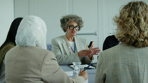 Professional mature woman leads business discussion