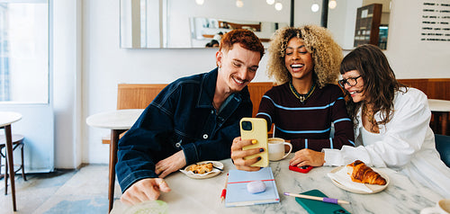 Friends taking a selfie at a cozy cafe
