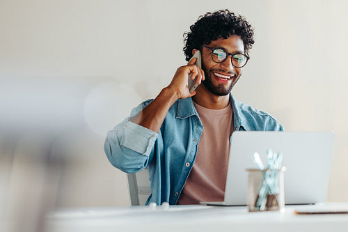 Young businessman engaged in a phone call at work