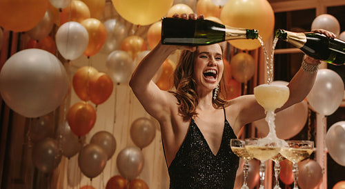 Excited woman filling up pyramid of champagne 