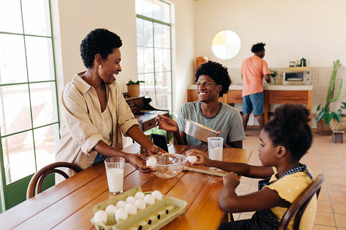 Happy Brazilian family making cheese bread together in the kitchen