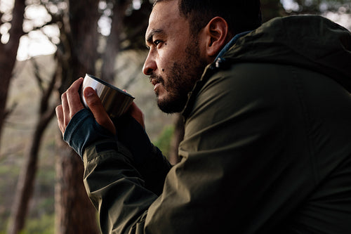 Male hiker taking rest and having coffee outdoors