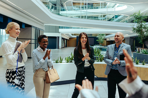 Corporate team celebrating success in modern office environment