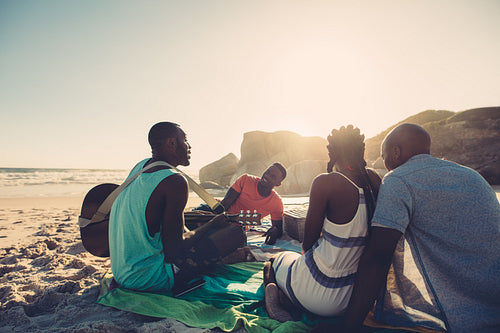 Group of four people having great time at the beach