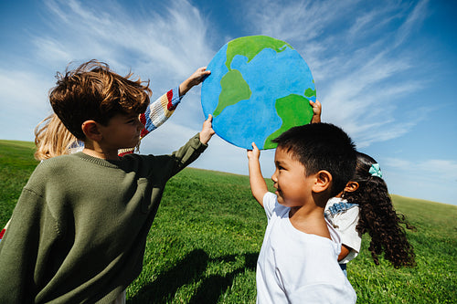 Children lifting globe to promote caring for the planet