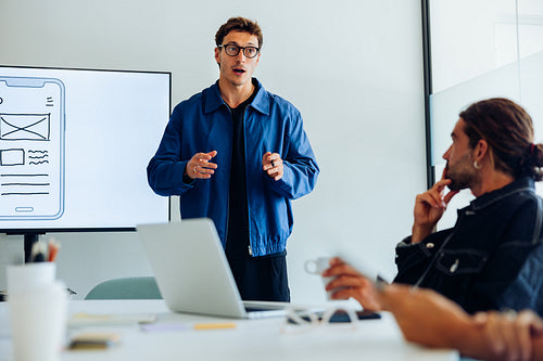 Designers present user flow to team in meeting