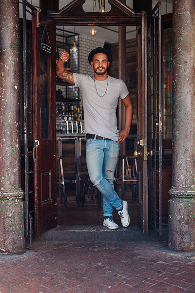 Modern young guy standing at the entrance of a coffee shop