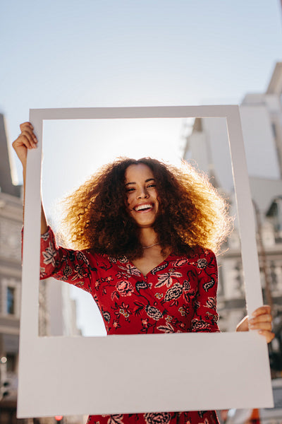Beautiful woman holding a blank photo frame