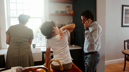 Working dad coming into the kitchen to have breakfast with his wife and son before going to work