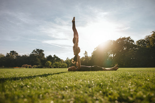 Couple doing pair yoga in park