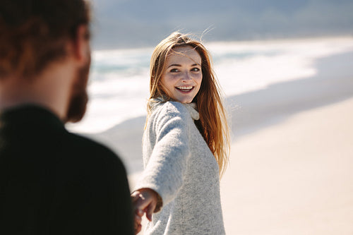 Beautiful woman walking with her boyfrined on beach