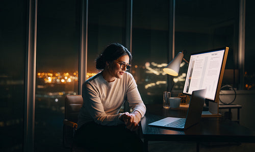 Business woman having a virtual meeting while working late in her home office