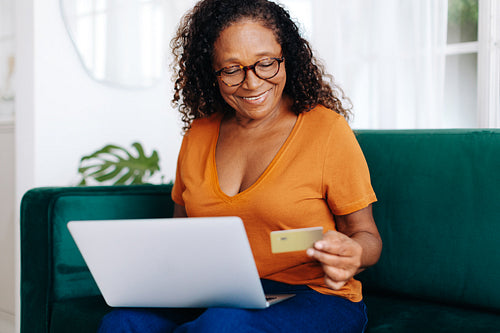Retired senior woman spoiling herself with online shopping at home