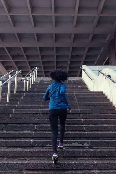 Back view of woman running up the stairs