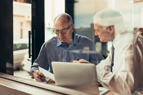 Business men discussing over documents in a restaurant