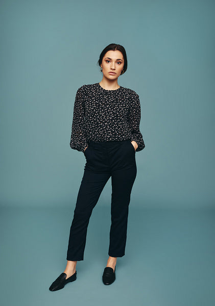 Confident young woman standing alone in a studio