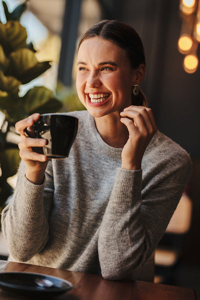 Cheerful woman enjoying a cup of coffee