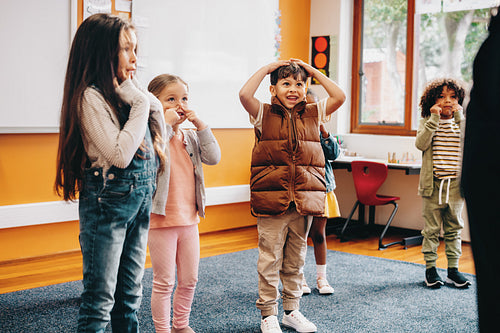 Kids sing and move along to an educational rhyme in a classroom
