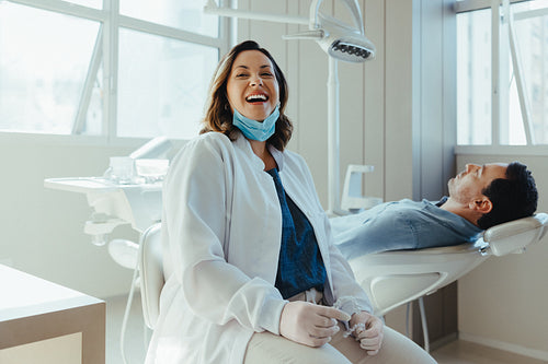 Dentist consultation in a bright clinic shows the woman supporting her patient