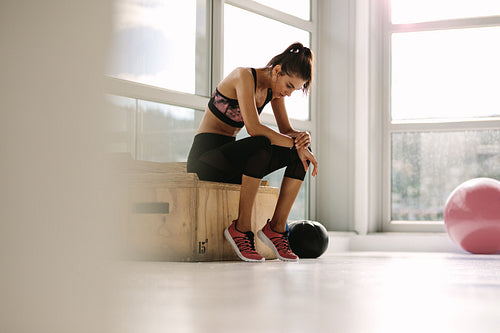 Young woman resting after workout at gym