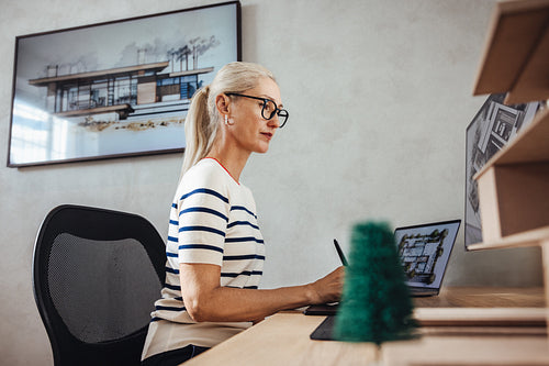 Mature female architect working on a project in a modern office