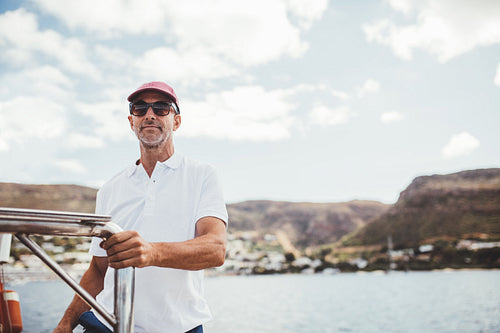 Handsome mature man standing on a boat