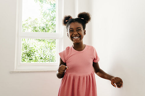 Young afro girl standing indoors at home, happy and confident