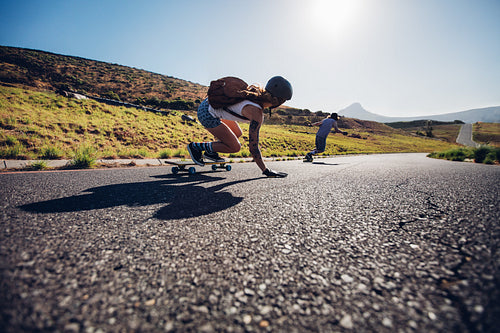 Friends longboarding down the road