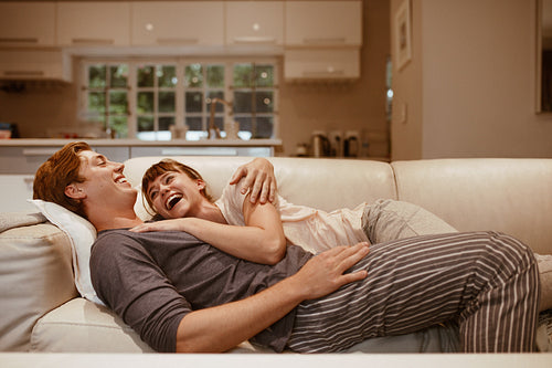 Smiling couple lying on a couch together