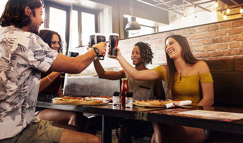 Multi-ethnic group of friends toasting soft drinks at cafe