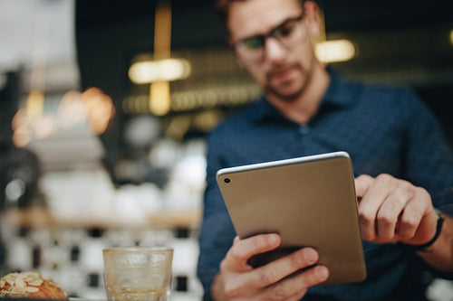 Entrepreneur using a tablet computer sitting in a restaurant