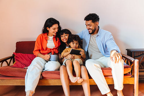 Happy family sitting on sofa and bonding together with a shared activity